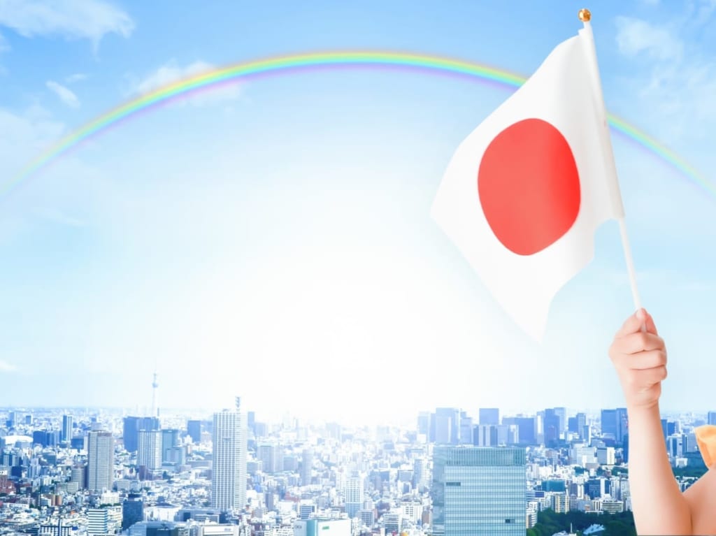 日の丸を持つ子どもとにじの背景